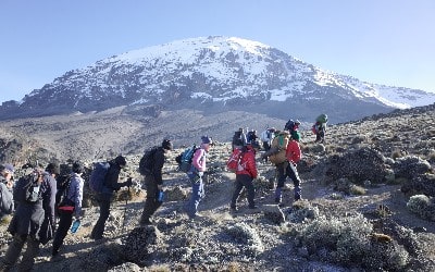 Vandrere i Tanzania med Kilimanjaro i baggrunden